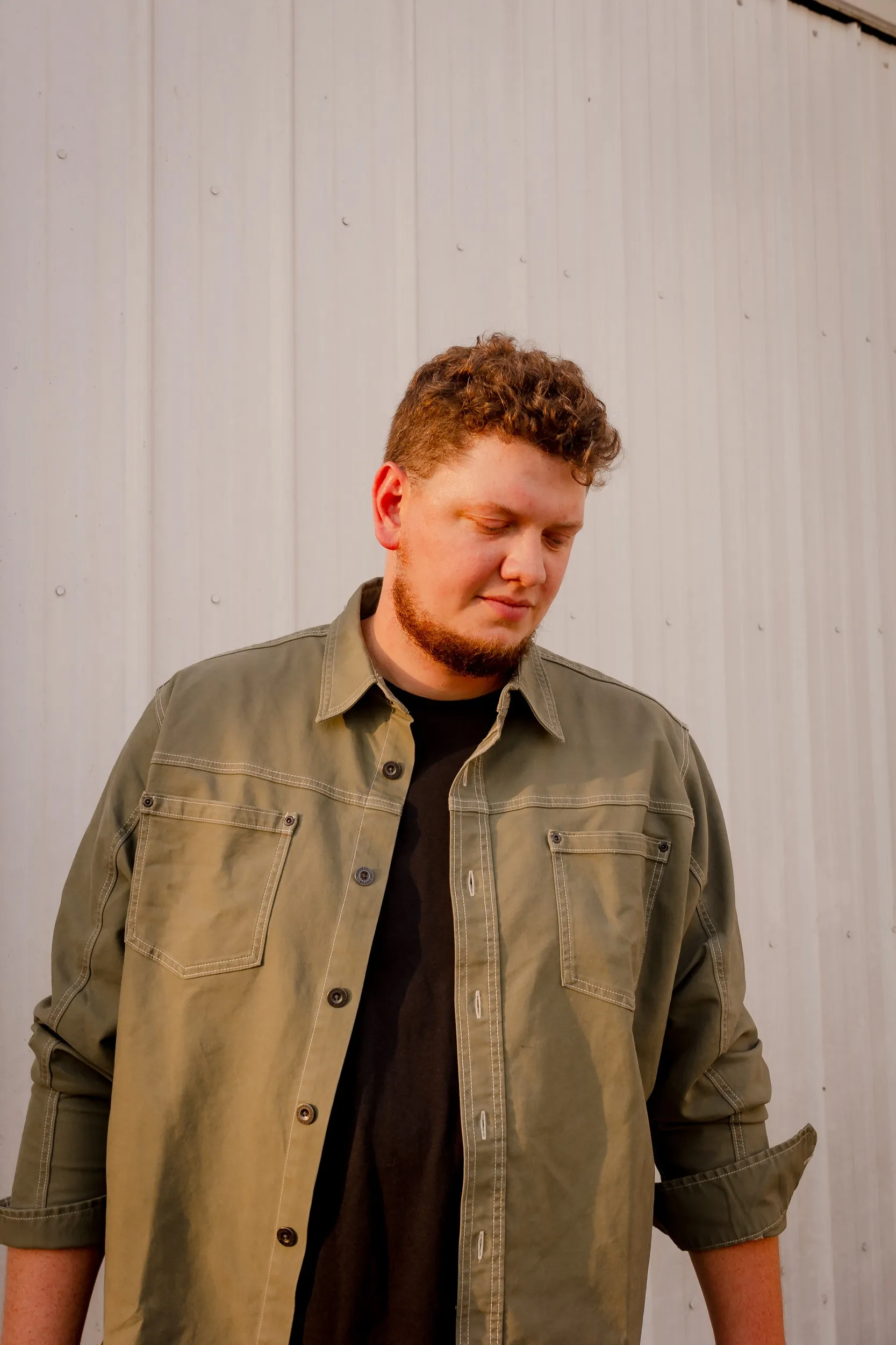 Portrait of Isaac Buschur against a white barn wall
